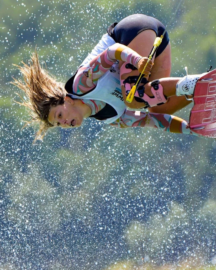 Alizé Piana tucked mid-air through a curtain of spray