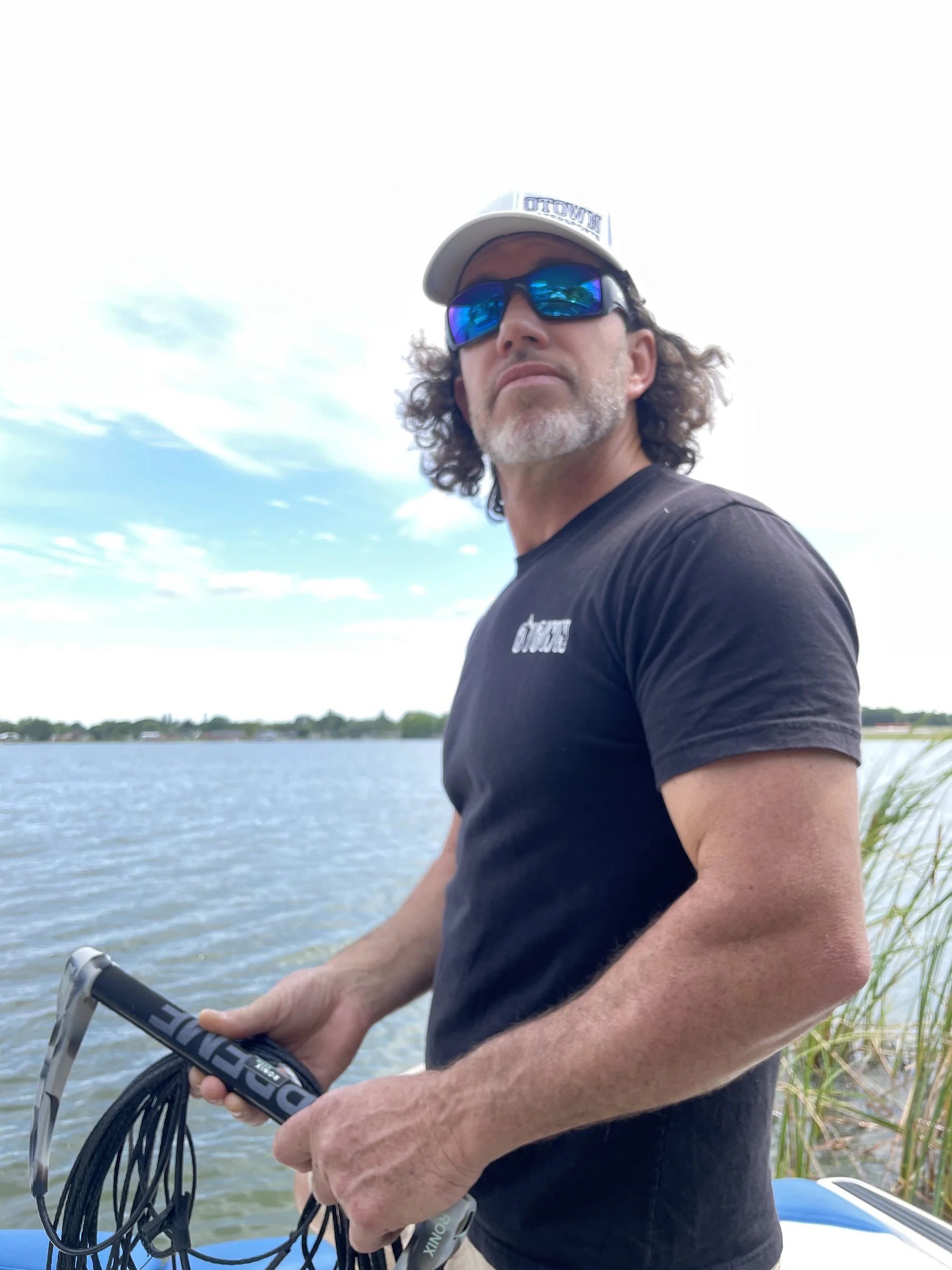 Glen Fletcher at the helm, handle in hand, watching the lake