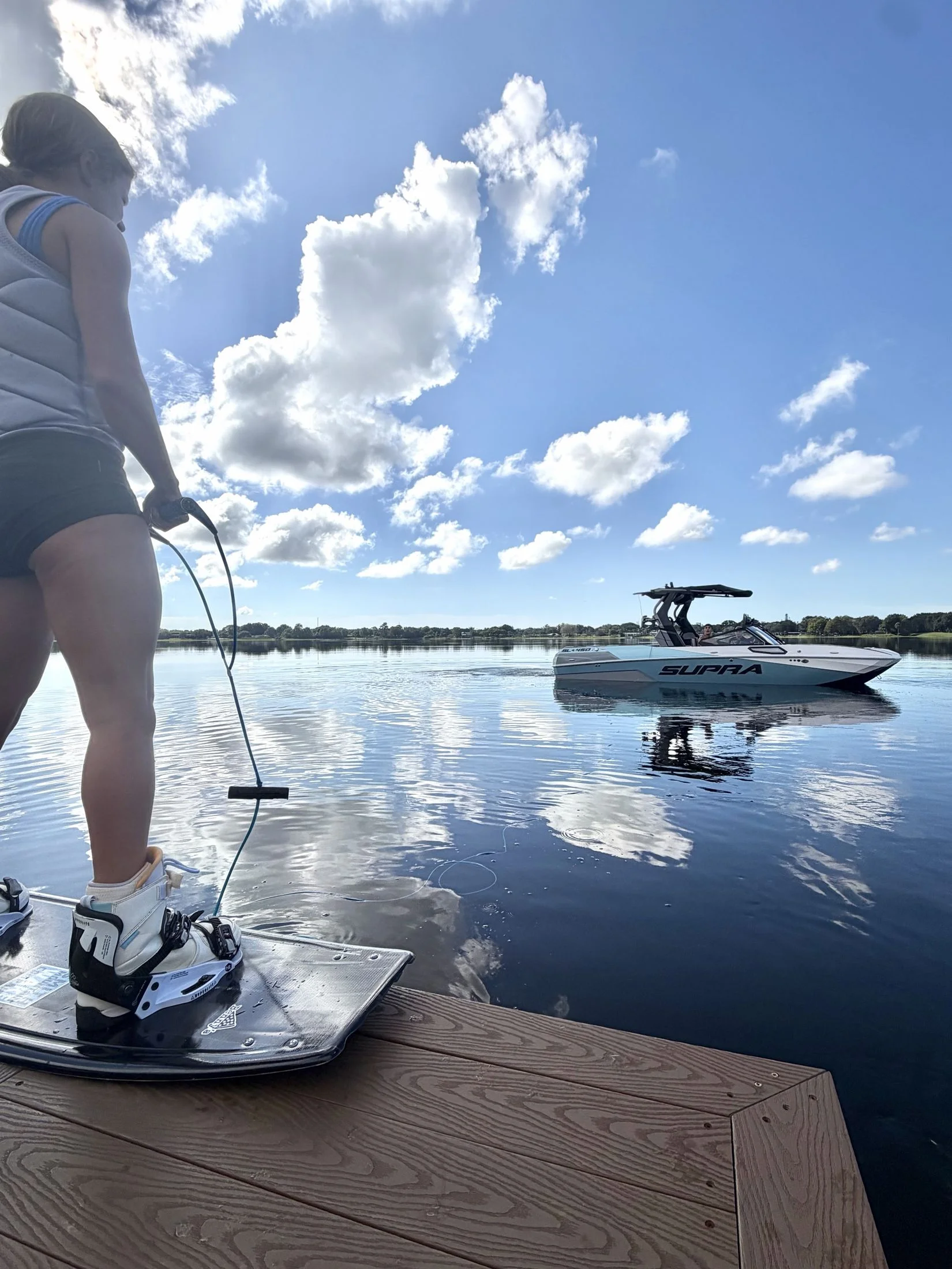 A rider ready for a dock start, the new Supra SL 450 waiting on the lake