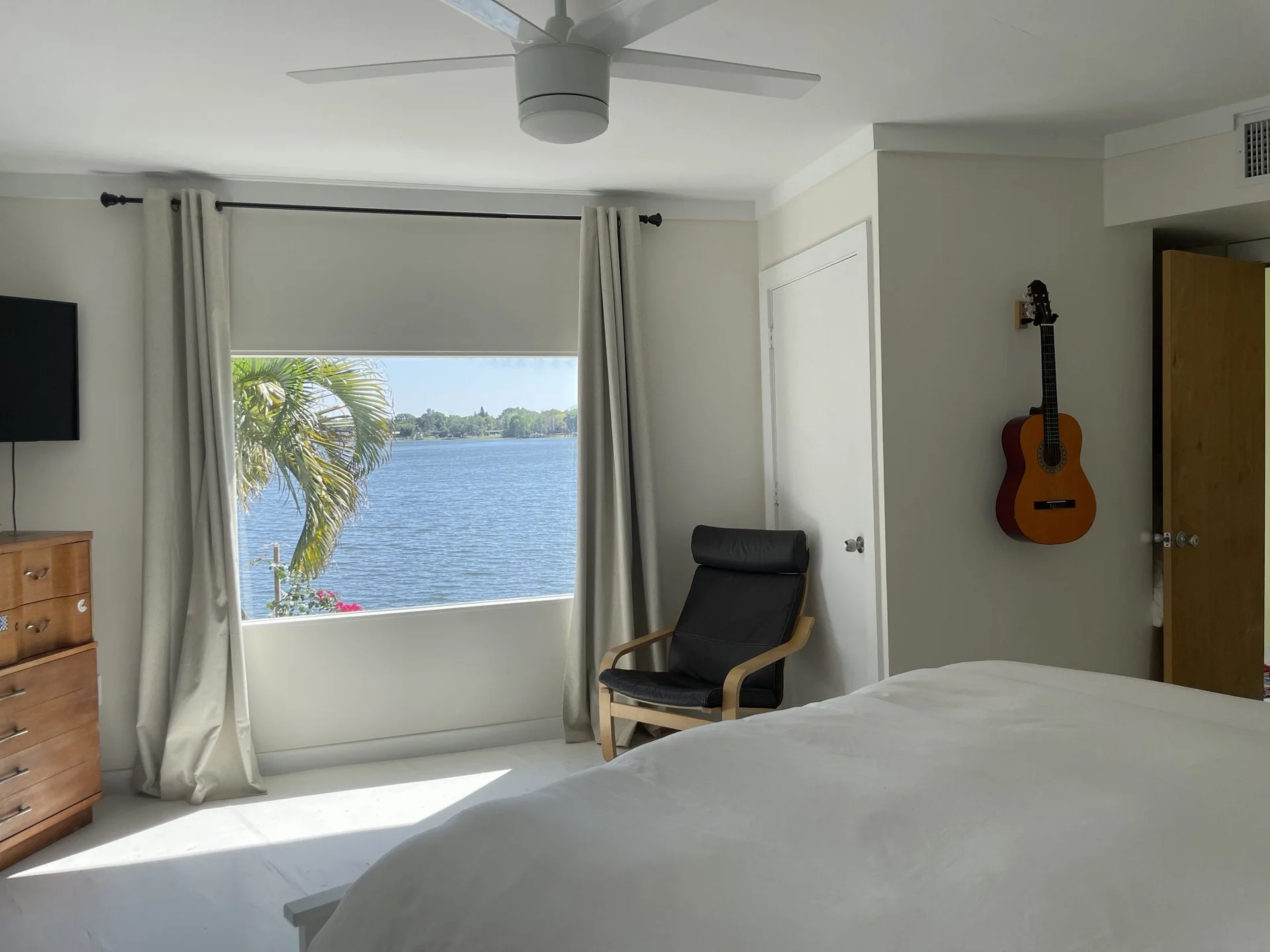 A bright bedroom at O’Town with a window looking straight onto Lake Barton