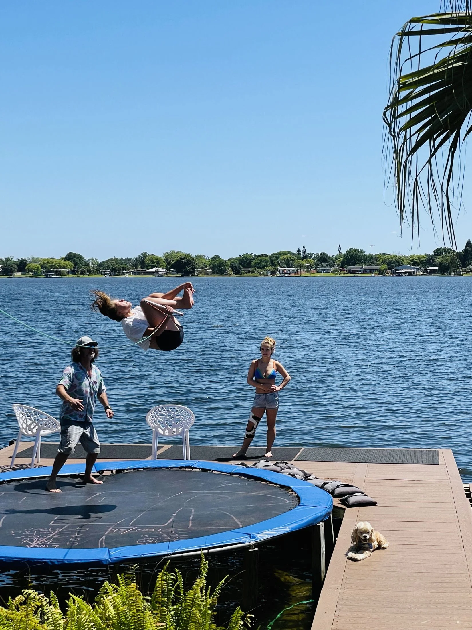 A rider flips on the lakeside trampoline