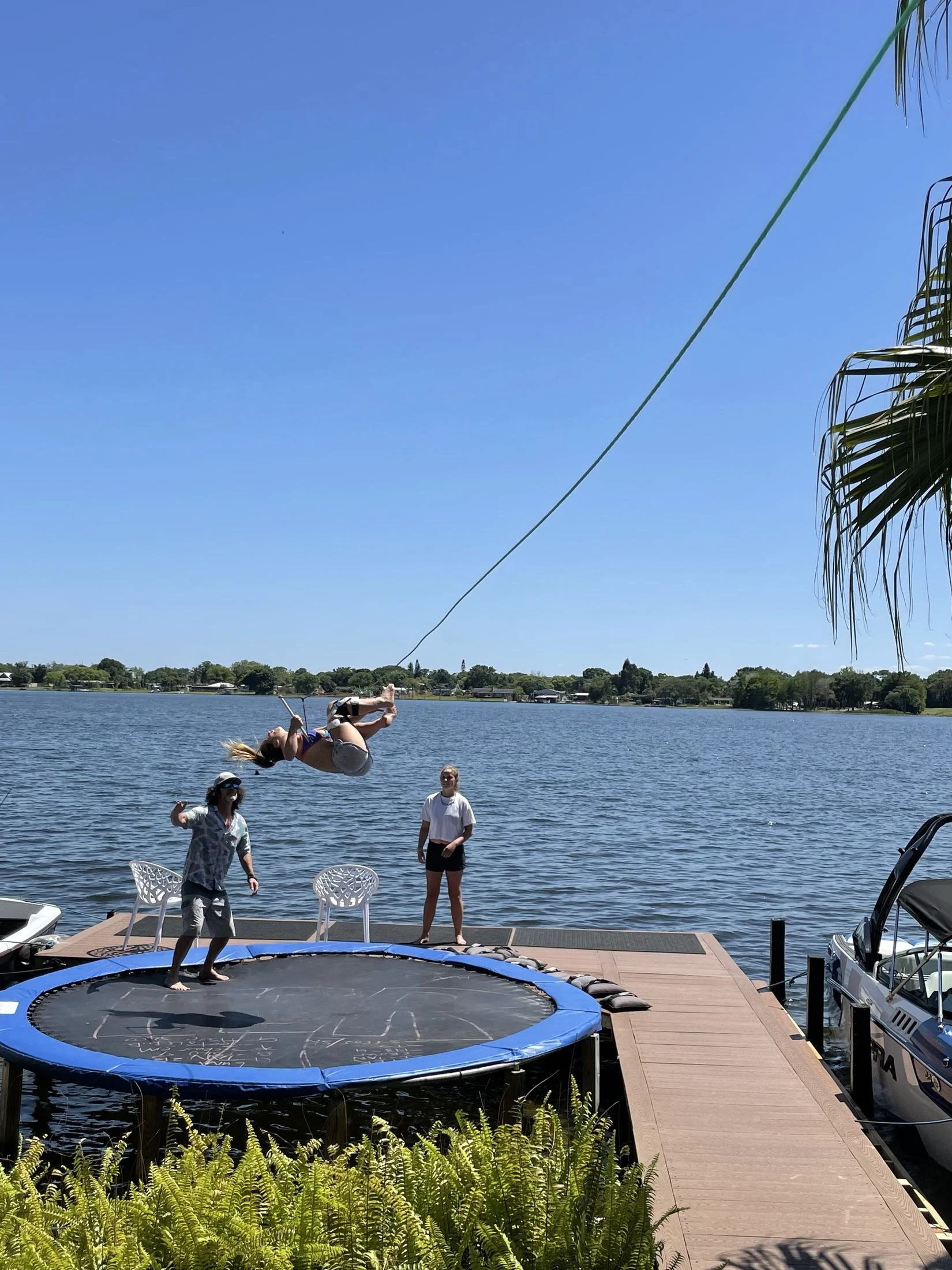 A rider flipping on the lakeside trampoline