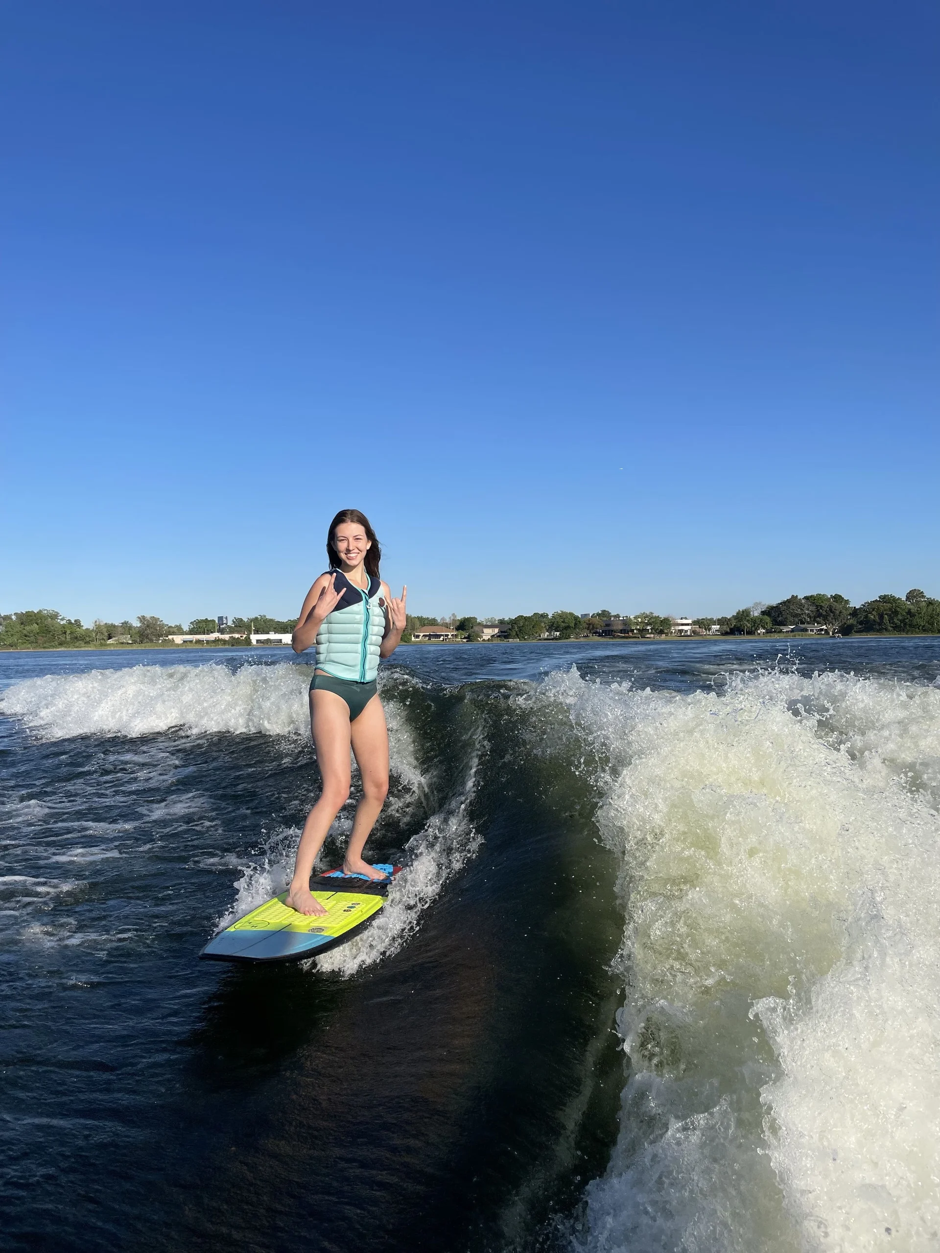 A rider wakesurfing behind the boat on Lake Barton