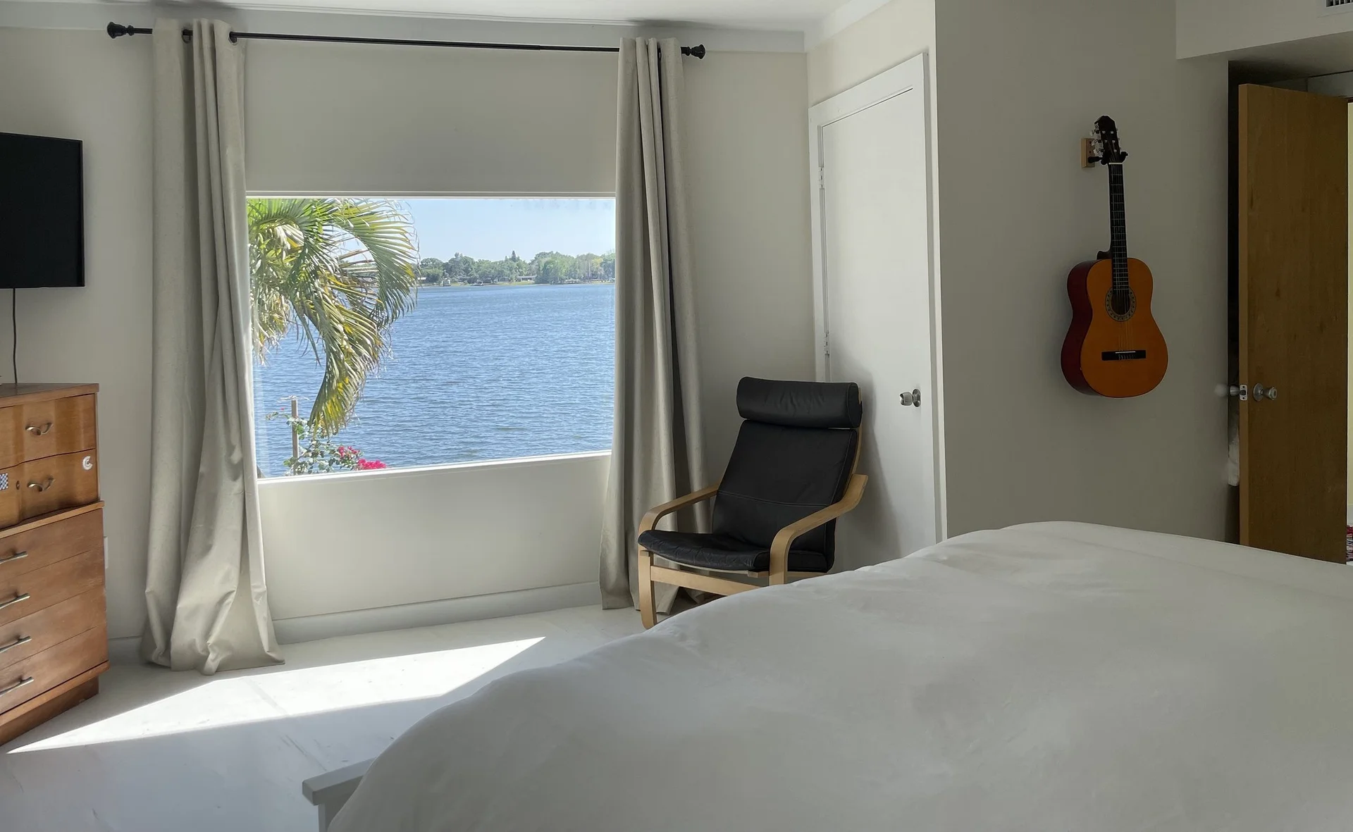 A bright bedroom with a window looking onto the lake